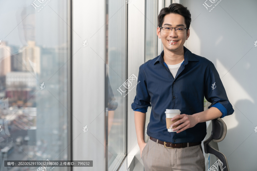 年轻商务男士在办公室喝咖啡