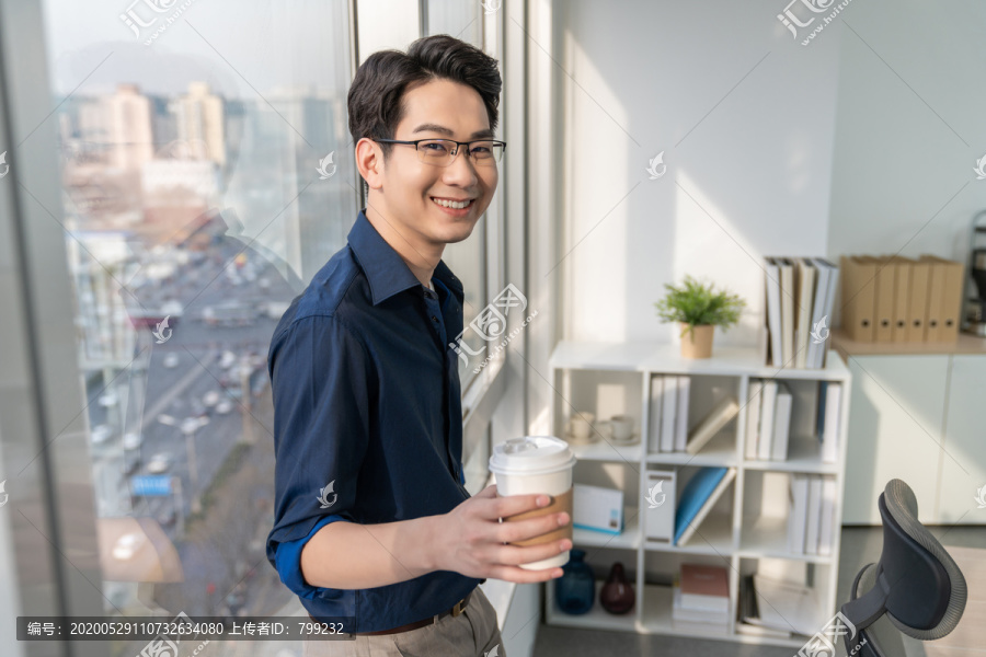 年轻商务男士在办公室喝咖啡