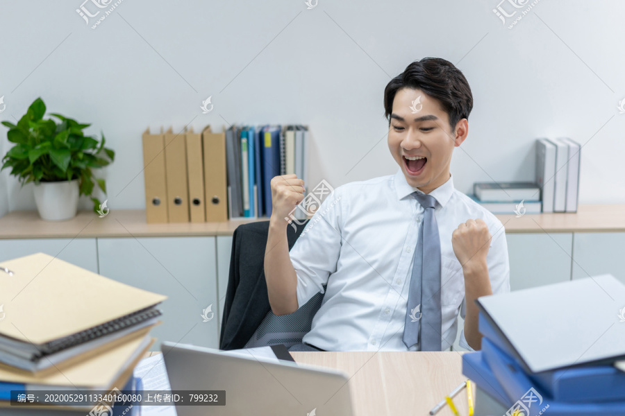 快乐的商务男士在办公室加班