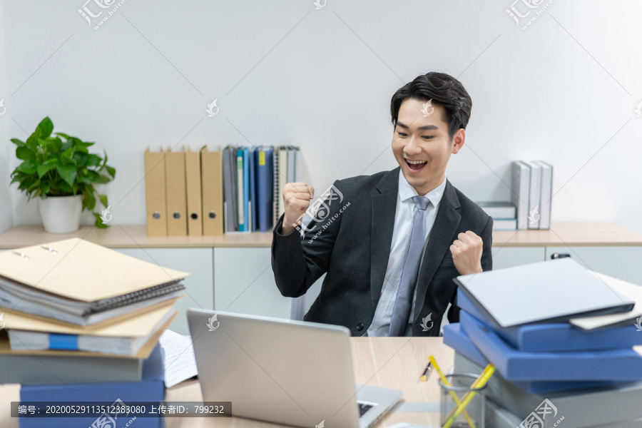 快乐的商务男士在办公室加班