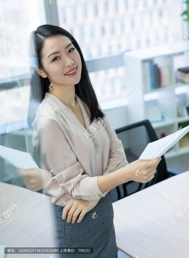 年轻商务女士拿着文件