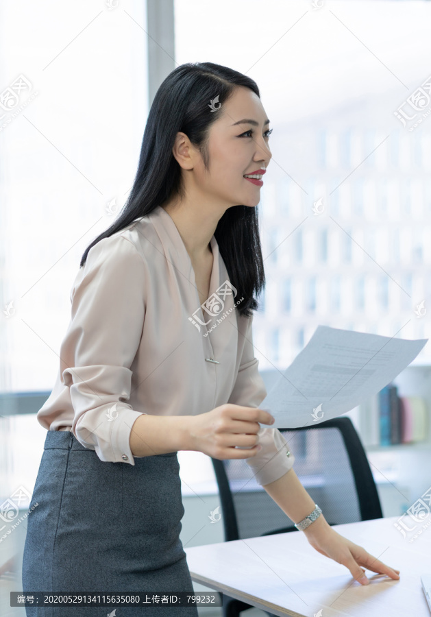 年轻商务女士拿着文件