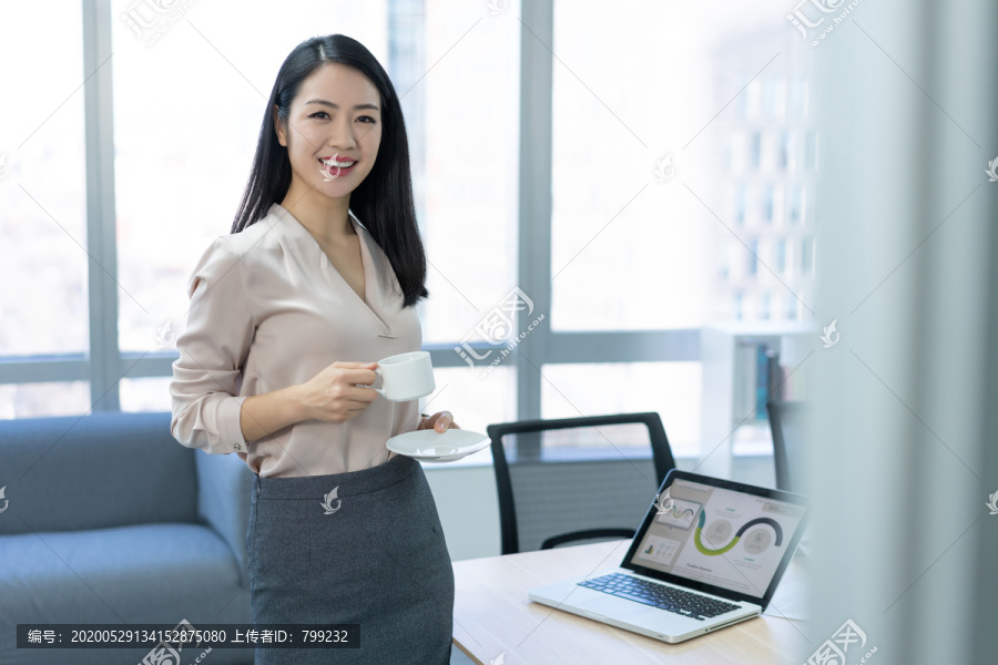 年轻商务女士在办公室喝咖啡