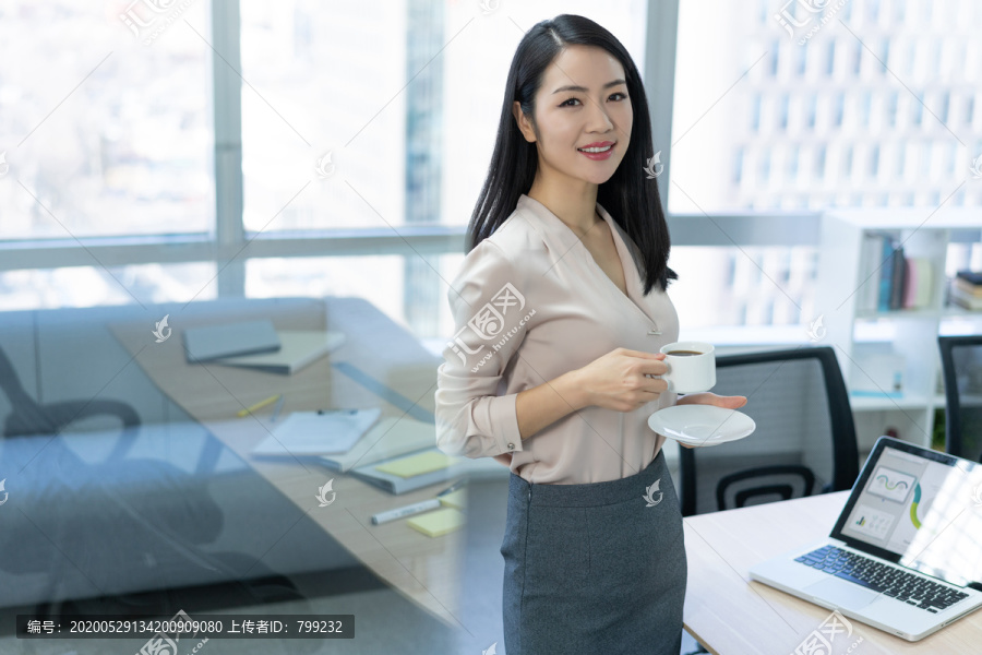 年轻商务女士在办公室喝咖啡
