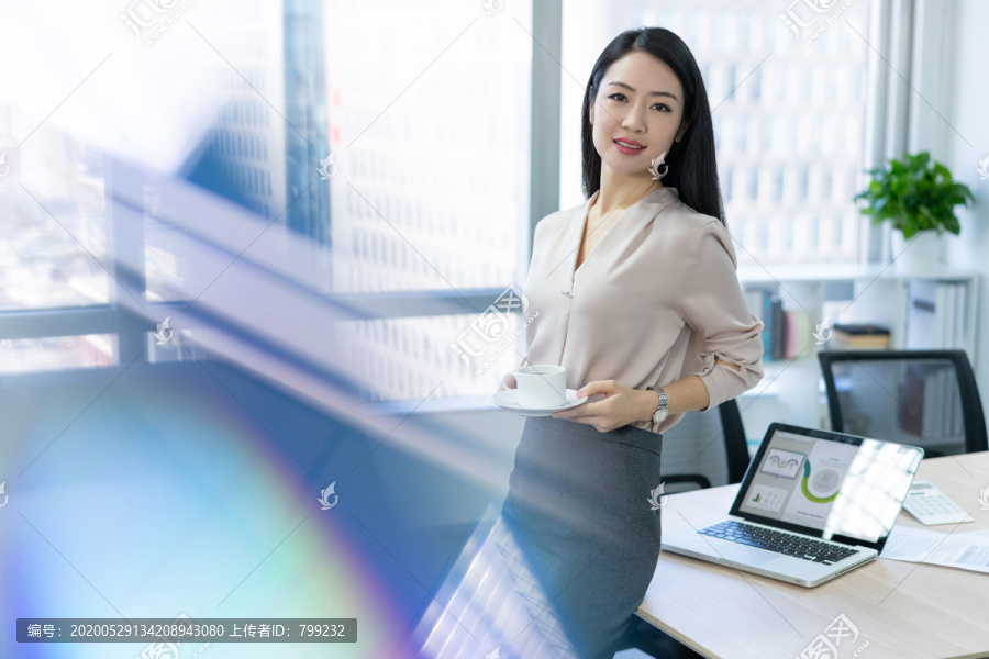 年轻商务女士在办公室喝咖啡