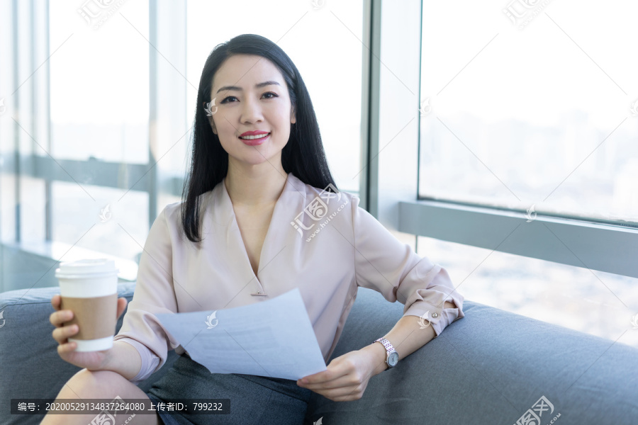 年轻商务女士在办公室喝咖啡