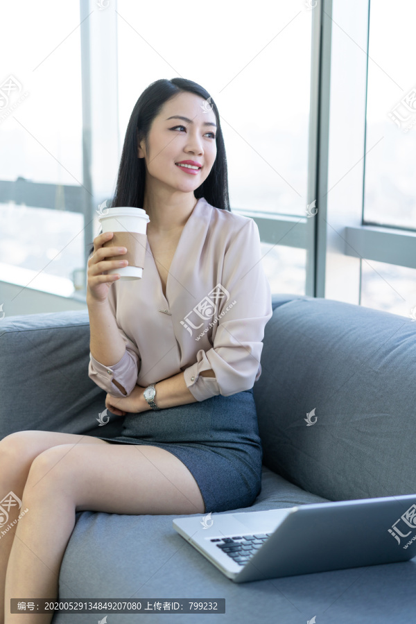 年轻商务女士在办公室喝咖啡