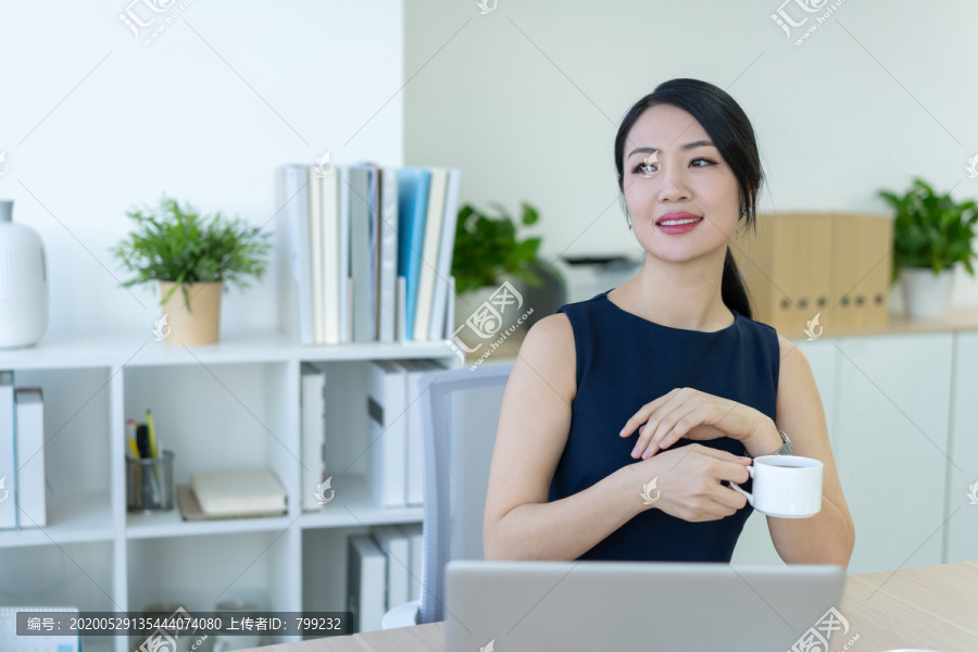 年轻商务女士在办公室喝咖啡