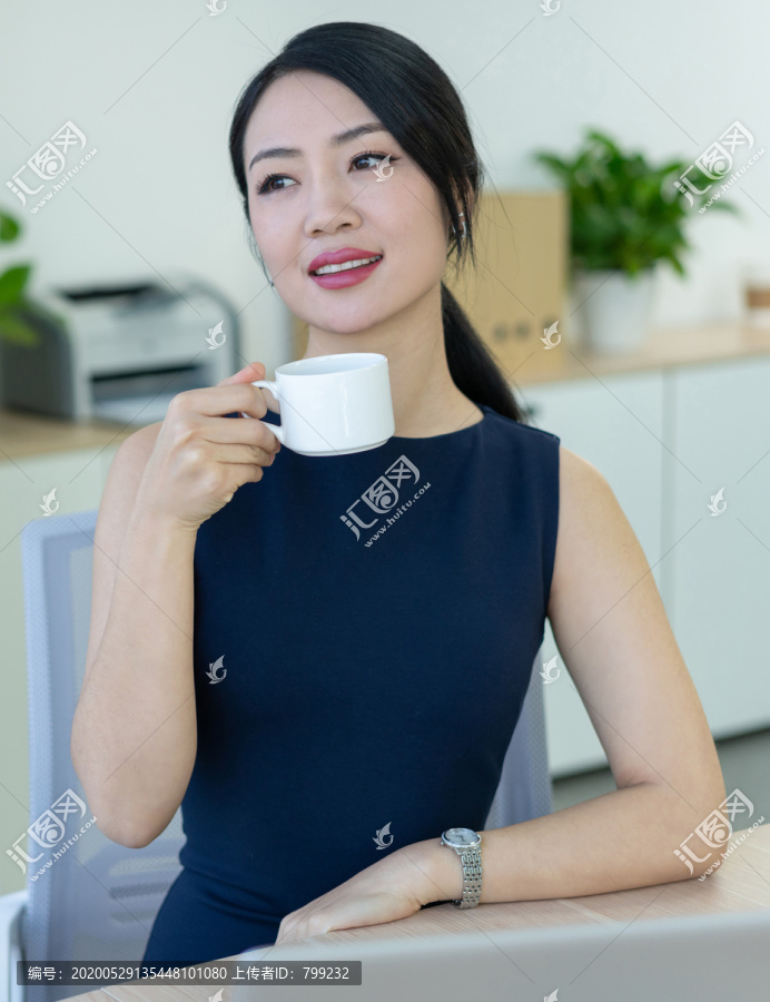 年轻商务女士在办公室喝咖啡