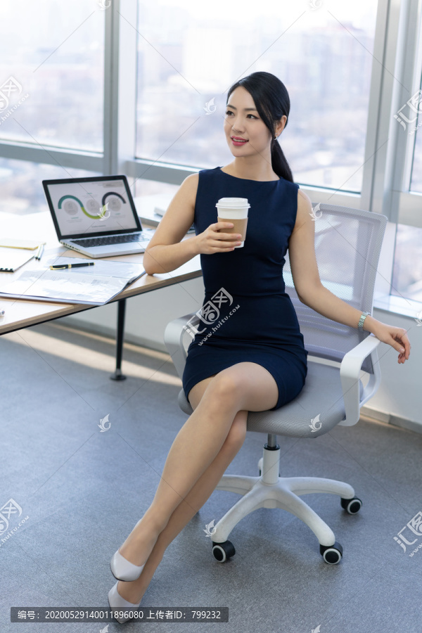 年轻商务女士在办公室喝咖啡