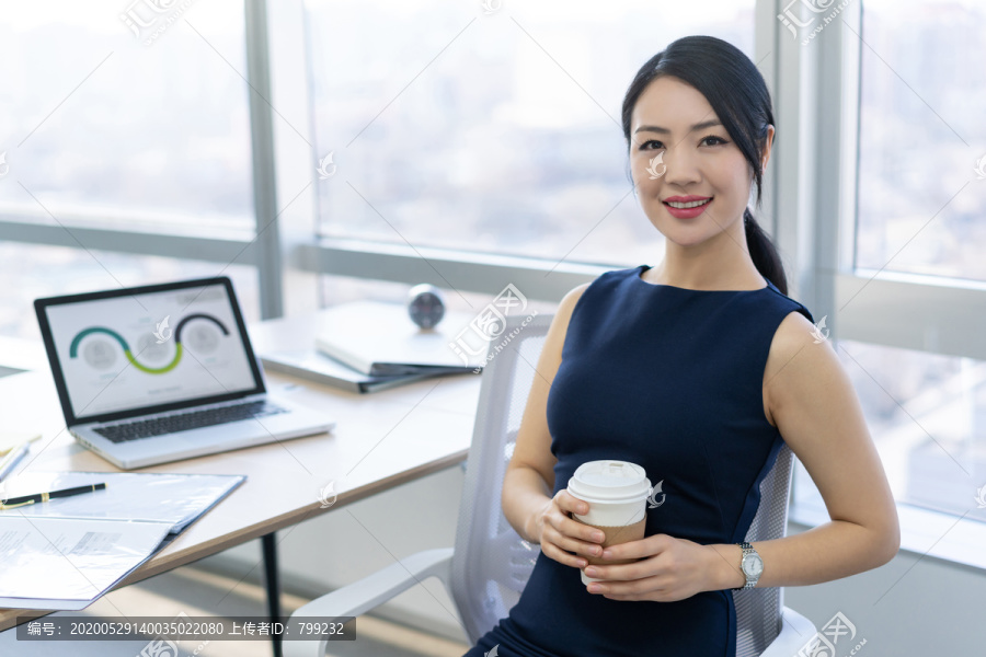 年轻商务女士在办公室喝咖啡
