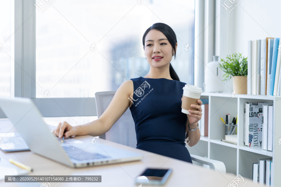 年轻商务女士在办公室喝咖啡