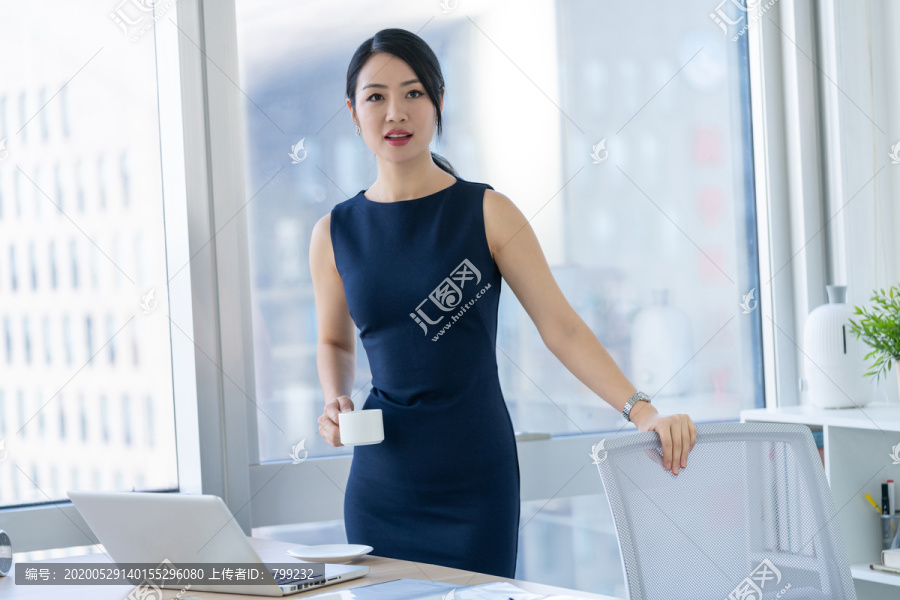 年轻商务女士在办公室喝咖啡