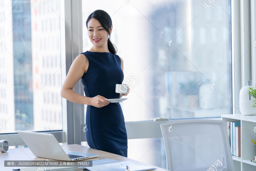年轻商务女士在办公室喝咖啡