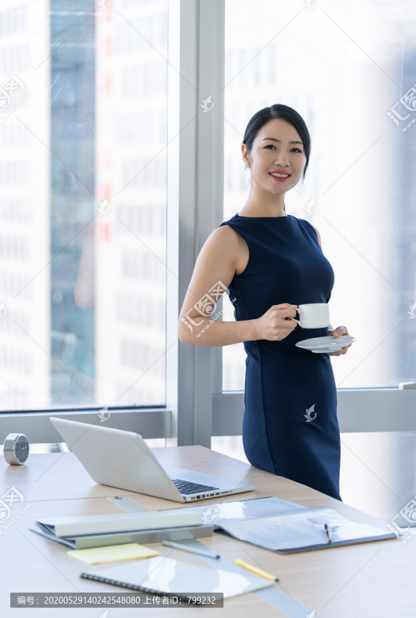 年轻商务女士在办公室喝咖啡