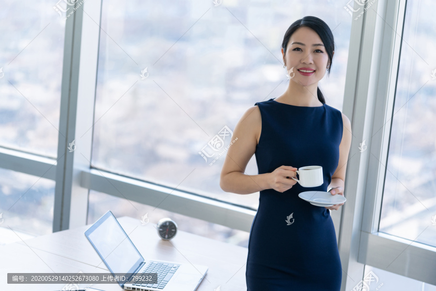 年轻商务女士在办公室喝咖啡