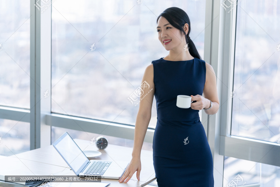 年轻商务女士在办公室喝咖啡