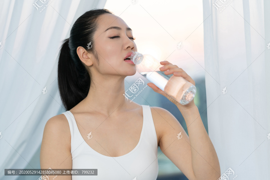 快乐的年轻女子喝矿泉水