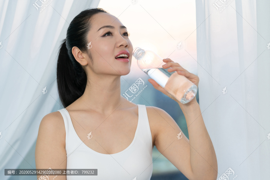 快乐的年轻女子喝矿泉水