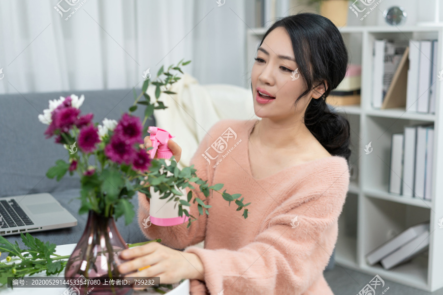 年轻女子在家浇花