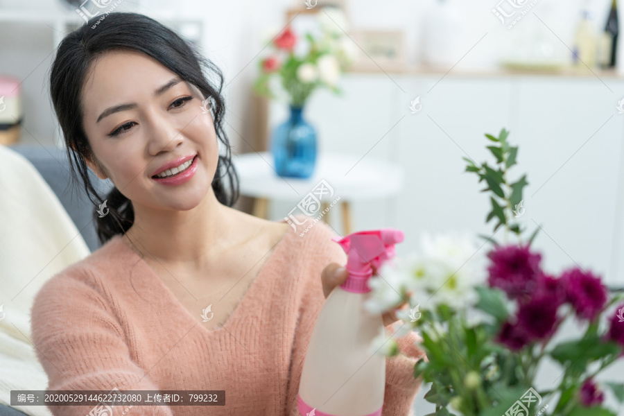 年轻女子在家浇花