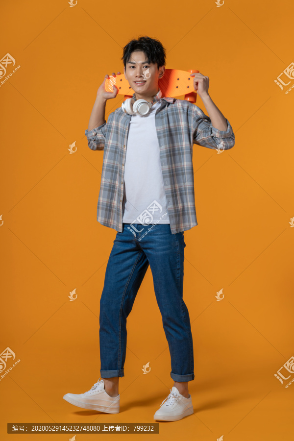 拿着滑板的年轻男子