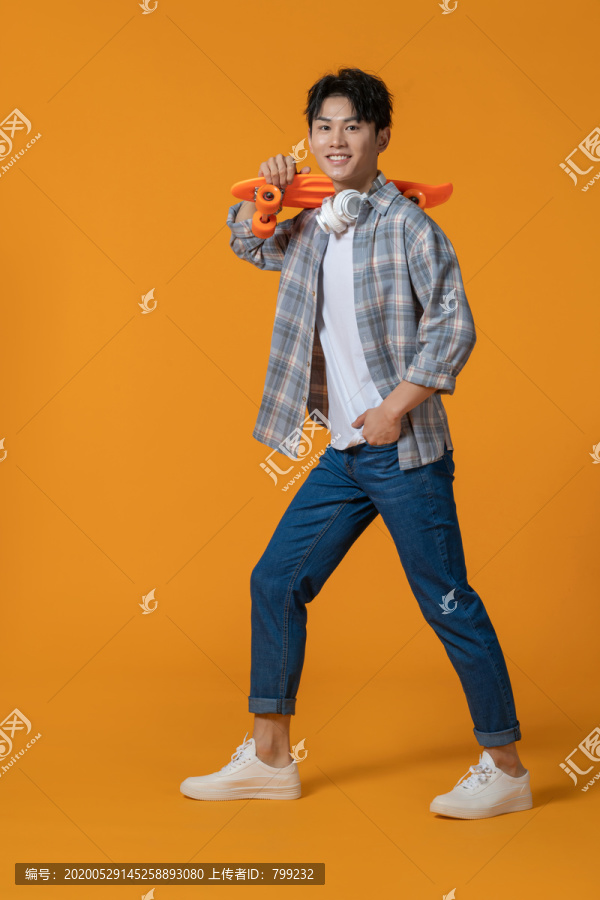 拿着滑板的年轻男子
