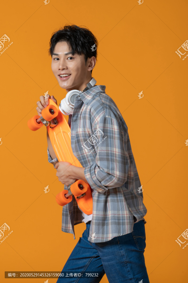 拿着滑板的年轻男子