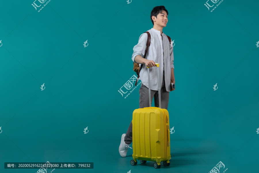 棚拍拿着行李箱的年轻男子