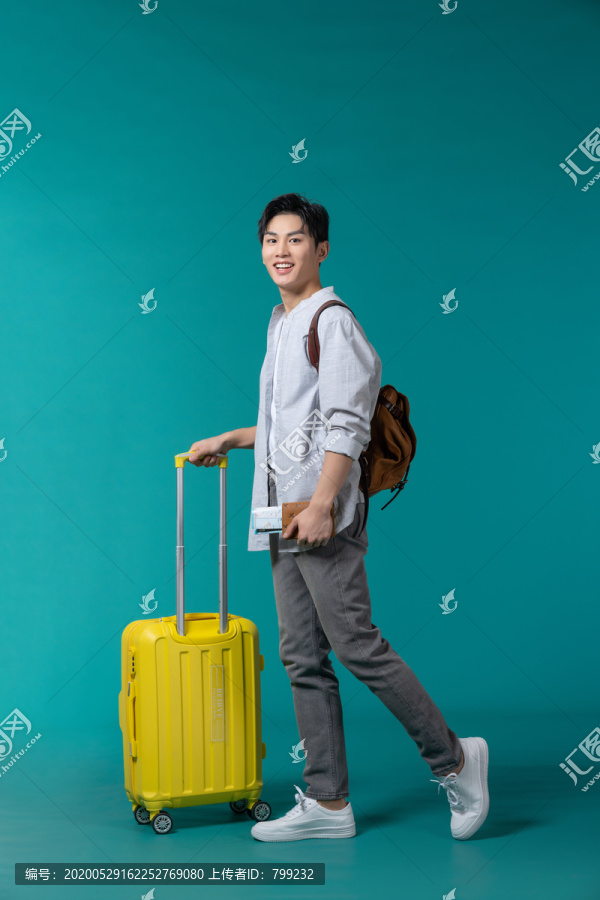 棚拍拿着行李箱的年轻男子