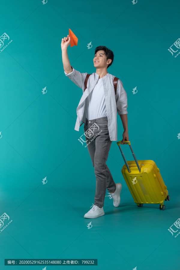 棚拍拿着行李箱的年轻男子