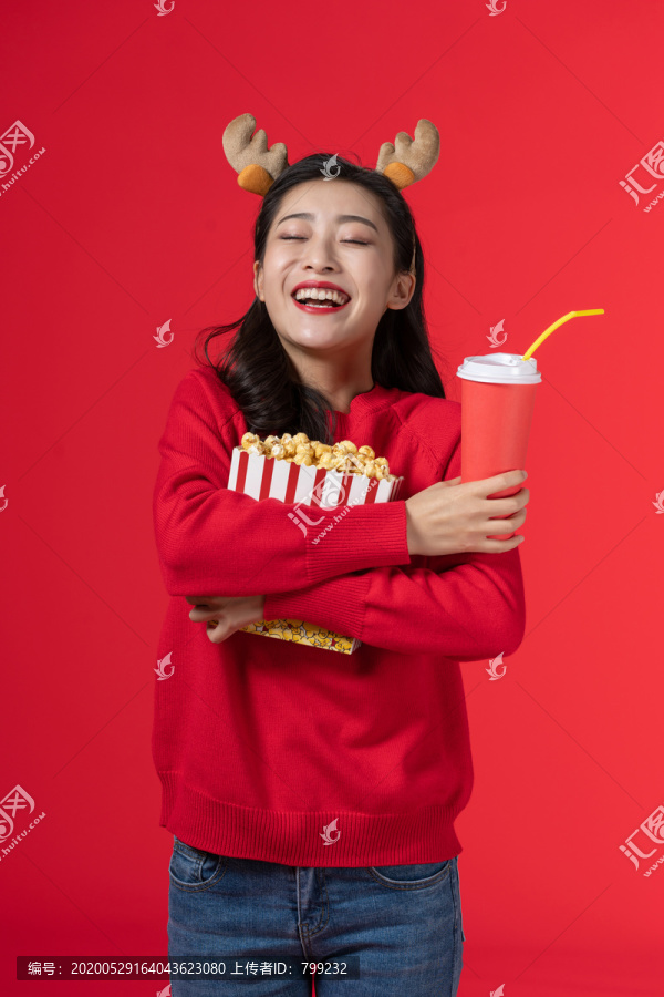 拿着爆米花和饮料的快乐女子