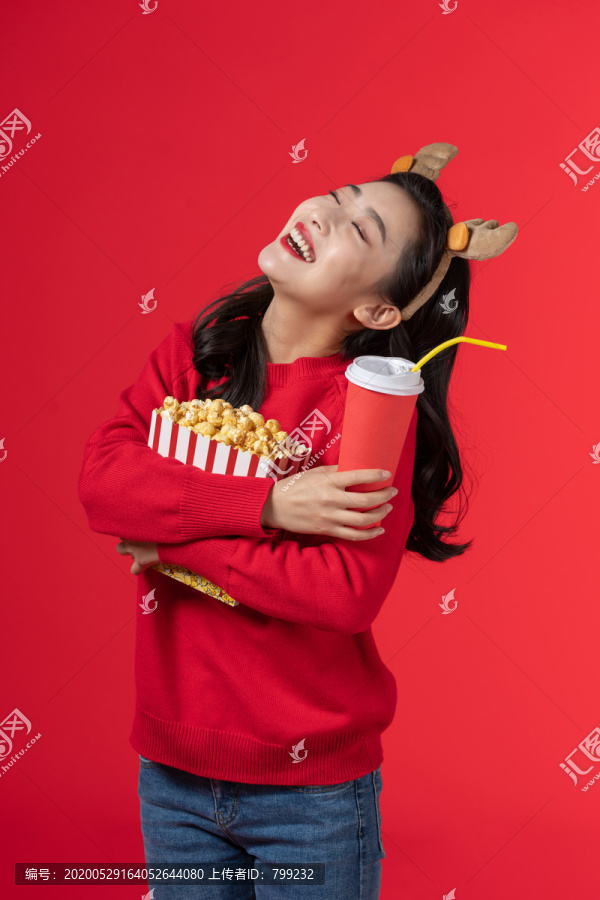 拿着爆米花和饮料的快乐女子