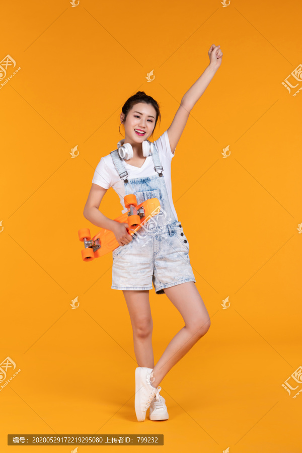 棚拍拿着滑板的年轻女子