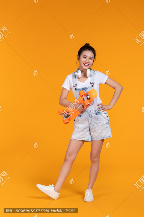 棚拍拿着滑板的年轻女子