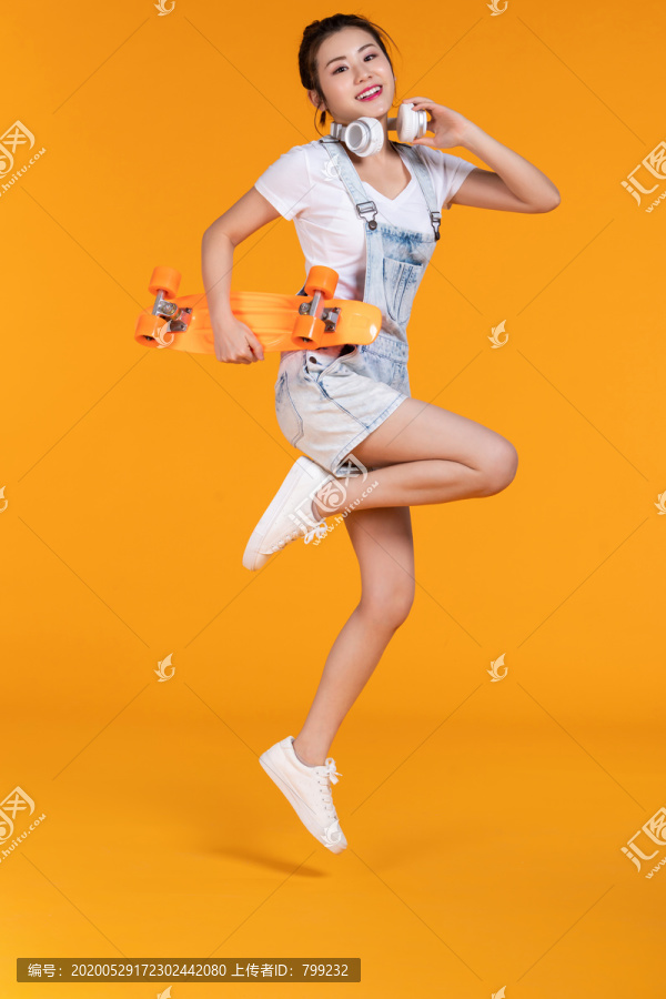 棚拍拿着滑板的年轻女子