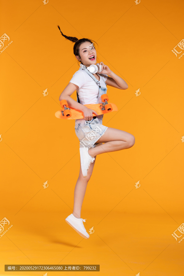 棚拍拿着滑板的年轻女子