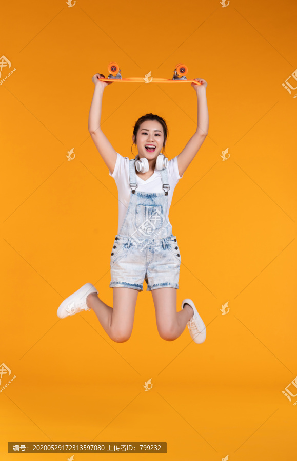 棚拍拿着滑板的年轻女子