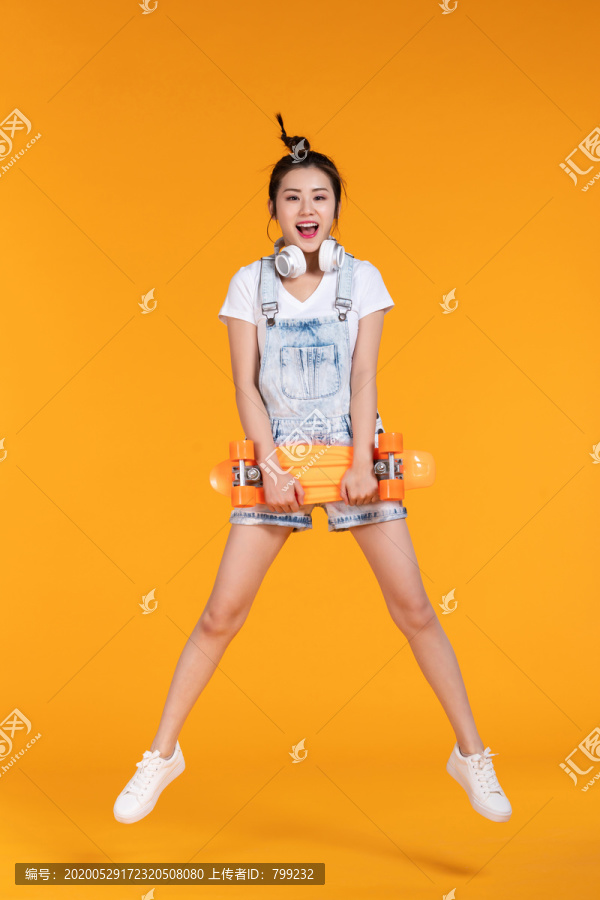 棚拍拿着滑板的年轻女子