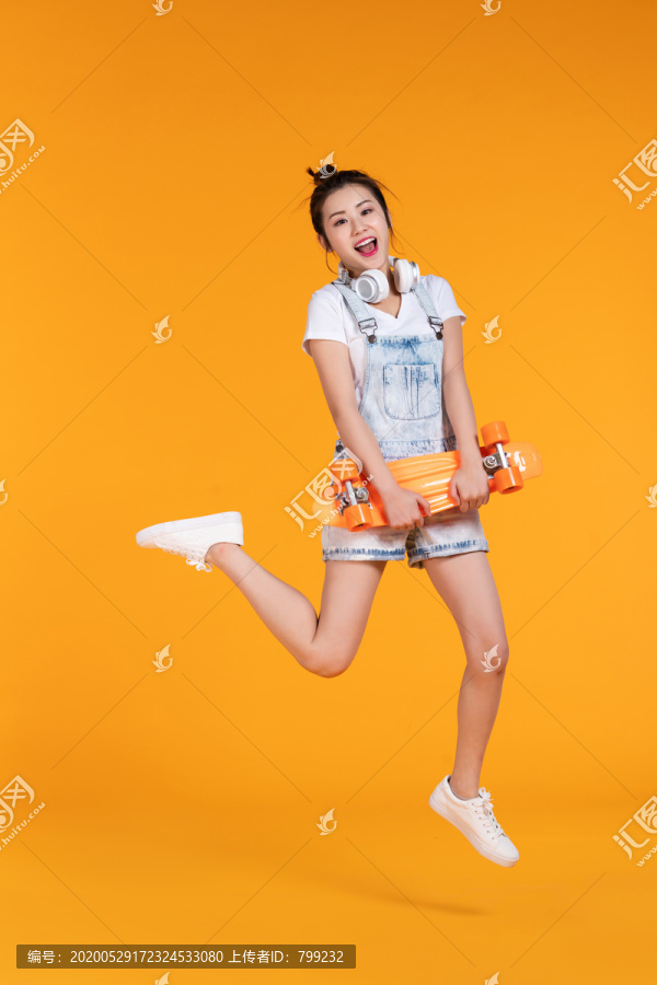 棚拍拿着滑板的年轻女子