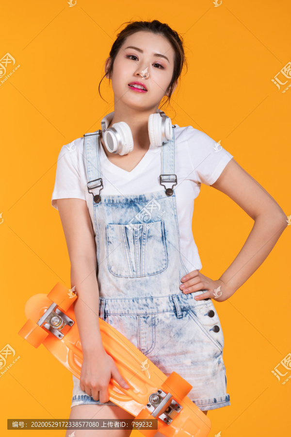 棚拍拿着滑板的年轻女子