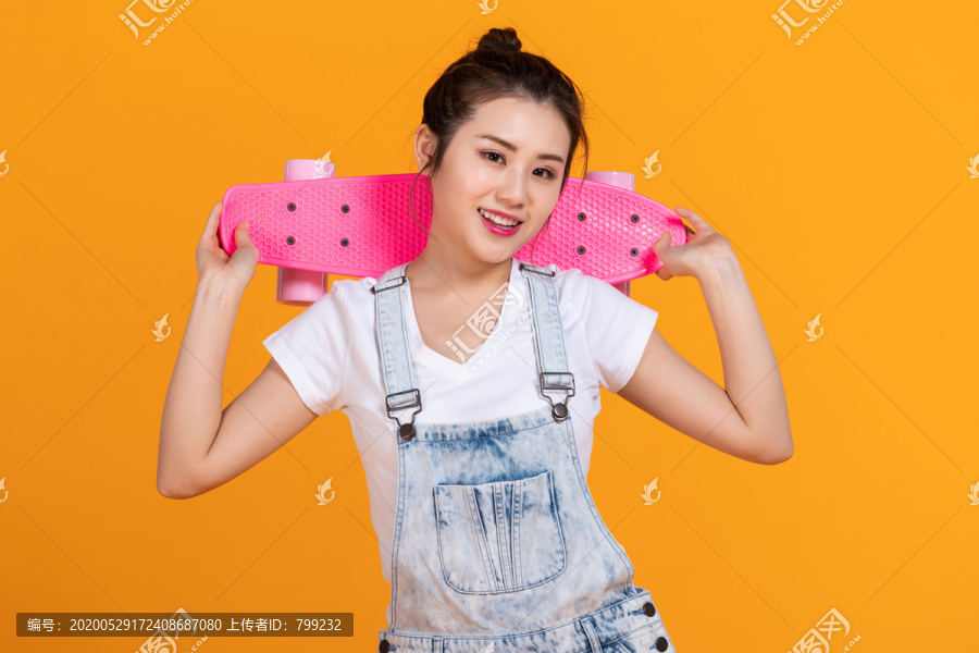 棚拍拿着滑板的年轻女子