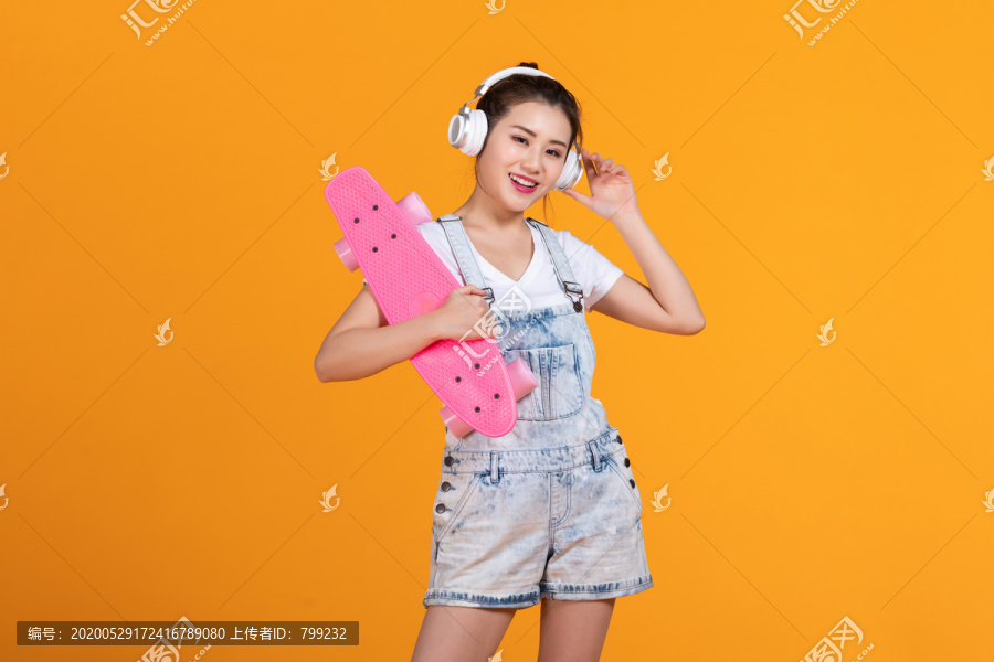 棚拍拿着滑板的年轻女子