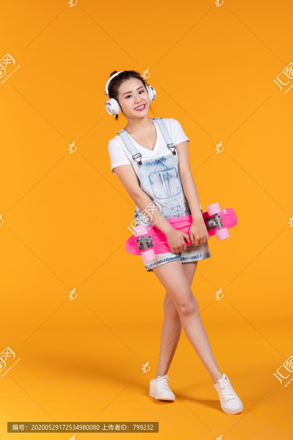 棚拍拿着滑板的年轻女子