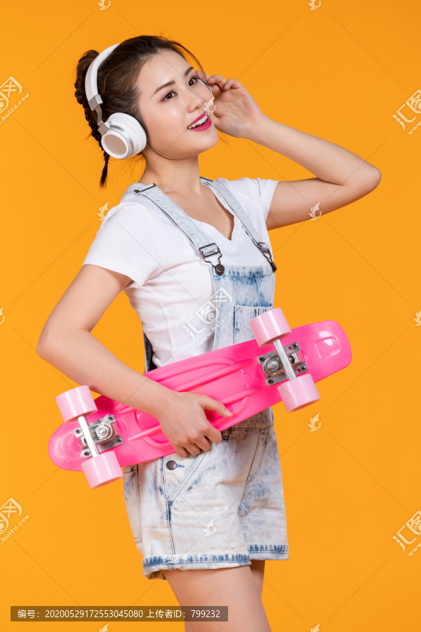 棚拍拿着滑板的年轻女子