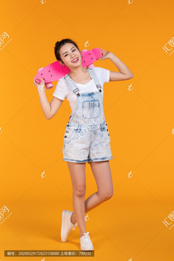 棚拍拿着滑板的年轻女子