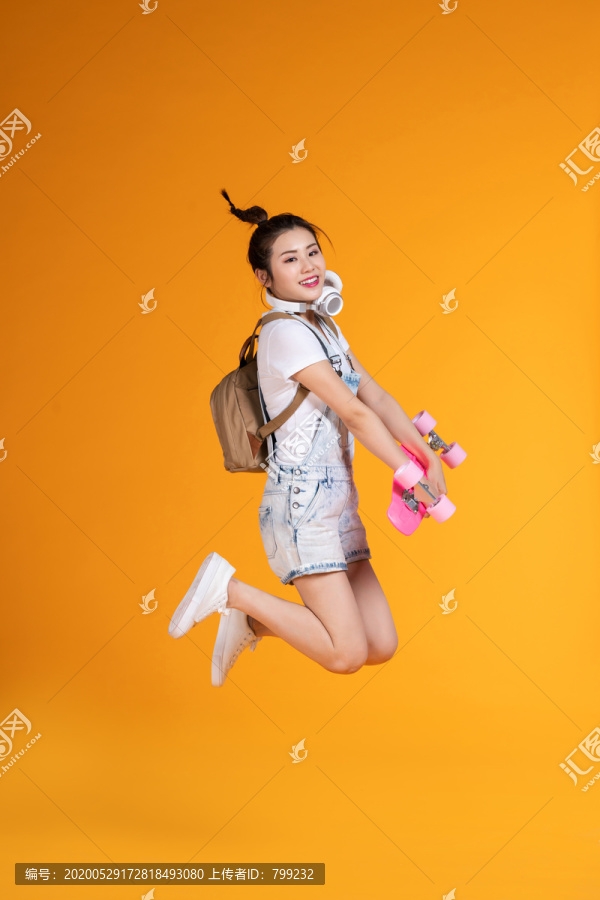 棚拍拿着滑板的年轻女子