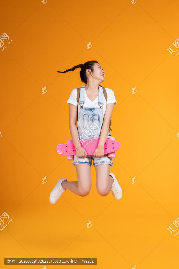 棚拍拿着滑板的年轻女子