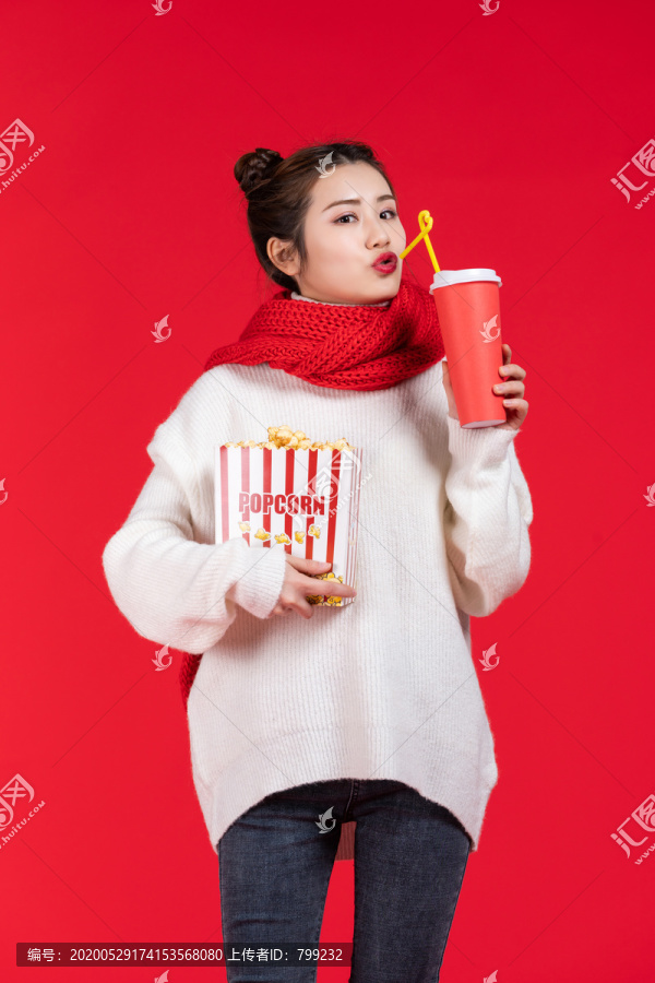 拿着爆米花和饮料的快乐女子