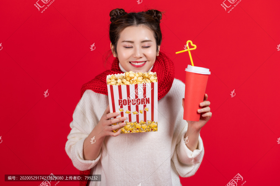 拿着爆米花和饮料的快乐女子